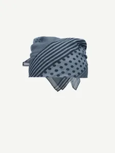 Close-up detail of blue-grey patterned scarf with polka dot and stripe design for women.