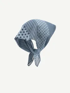 Close-up detail of blue patterned square scarf with stylish polka dots and classic stripes.