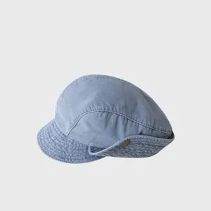 Detailed view of the vintage denim newsboy cap, showing the textured fabric and button.