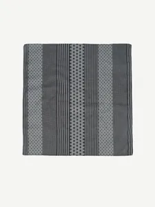 Close-up detail of the stylish geometric pattern, vertical stripes, and polka dots on a chic scarf.