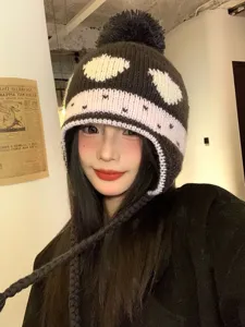 Cozy knit earflap beanie with cute pom-pom and playful pattern, warm winter fleece hat.