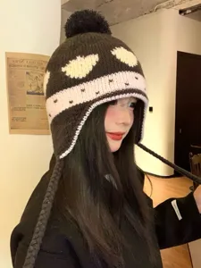 Cute strawberry knit earflap beanie with pom-pom and braided ties, warm winter hat detail.