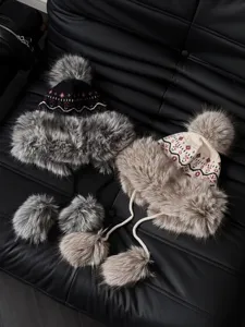 Close-up detail of ethnic jacquard trapper hat with cozy plush ear flaps and fluffy pom poms.