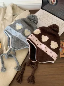 Cute winter knitted earflap beanie with pompom and heart jacquard pattern, warm and stylish.