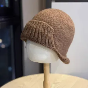 Detail shot of brown knitted irregular fisherman hat showcasing its soft texture and rolled brim.
