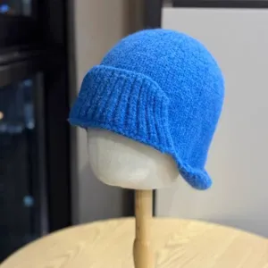 Blue knitted bucket hat detail, vintage rolled brim, cozy autumn winter headwear style.