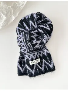 Black and purple fair isle knitted winter scarf detail view, cozy thickened warm neck wrap.