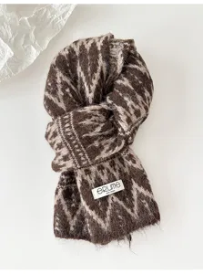 Detailed view of the Fair Isle knitted scarf, showcasing cozy brown jacquard and thick warm texture.