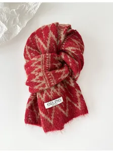 Knit scarf detail showing soft red and beige Fair Isle pattern texture and brand label close up.