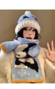 Dettaglio di berretto e sciarpa con pinguini, caldo accessorio invernale in lana da donna.