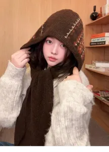 Gros plan détaillé de la cagoule en tricot marron avec motif ethnique chaleureux.