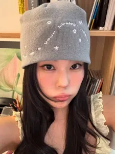 Grey knit beanie hat with cute white star and letter embroidery, stylish and cozy winter headwear.