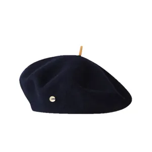 Detailed view of the dark blue wool beret featuring a unique top stick and side metal logo.