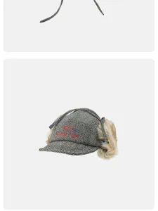 Detail view of retro plaid trapper hat with faux fur earflaps and vintage embroidered logo.