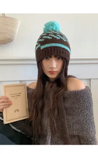 Vue détaillée du bonnet en tricot coréen avec pompon et protège-oreilles marron et bleu.