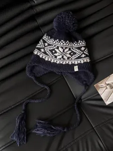 Navy blue knitted trapper hat with white Nordic jacquard pattern, pom-pom and earflaps.
