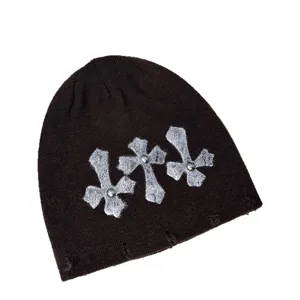 Dunkle Punk Strickmütze mit silbernen Kreuz-Patches und Nieten für stylische Streetwear Looks.