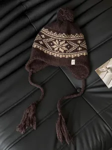 Knitted trapper hat with nordic jacquard pattern, warm earflap winter beanie detail.