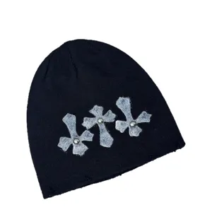 Schwarze Punk Strickmütze mit silbernen Kreuz-Patches und Nieten für Streetwear im Winter.