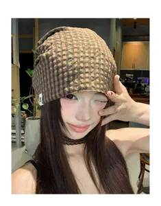 Detailansicht der braunen karierten Slouchy Beanie Mütze im Vintage-Stil für warme Sommertage.