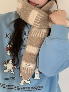 Primo piano di sciarpa invernale in morbida maglia con motivo elegante e trama accogliente.