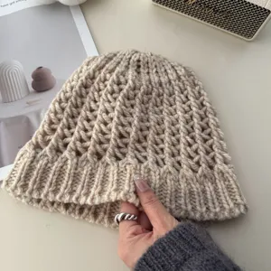 Detailed view of a trendy Korean style hollow knit beanie hat in light khaki, soft and chic.