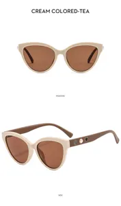 Detail view of cream colored cat-eye sunglasses featuring elegant camellia, pearl and heart decor.