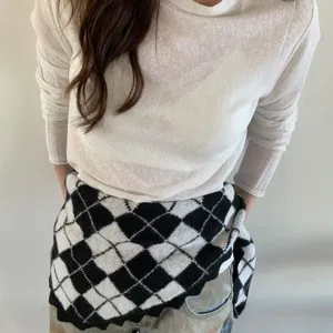 Detailaufnahme eines vintage schwarz-weißen Argyle-Strickdreiecktuchs in der Taille.