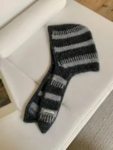 Dettaglio cappuccio sciarpa lavorato a maglia, morbido berretto invernale caldo.