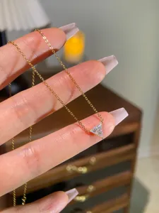 Delicate S925 silver triangle moissanite necklace, gold-plated cross chain jewelry detail view.