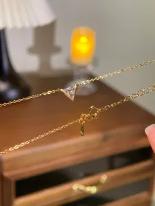 Detail shot of S925 sterling gold plated triangle moissanite necklace delicate chain clasp.