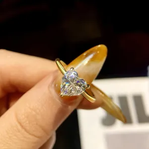 Detailaufnahme eines funkelnden Herzschliff Moissanit Ringes mit elegantem Goldband.