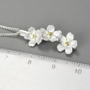 Nahaufnahme Detail der Silber Dreifachblume Anhänger Halskette mit Maßstab für genaue Größe.