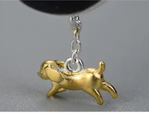 Primo piano dettaglio del ciondolo a forma di cagnolino in argento sterling dorato.