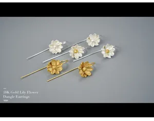 Closeup detail of elegant lily flower dangle earrings in gold and silver finish, stylish.