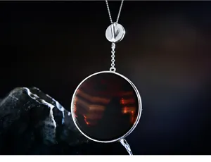 Élégant collier pendentif rond en argent avec pierre précieuse rouge foncé pour la mode quotidienne.