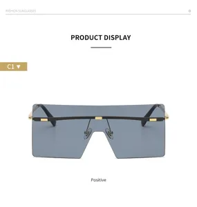 Occhiali da sole oversize alla moda con barra superiore in metallo e lenti grigie.
