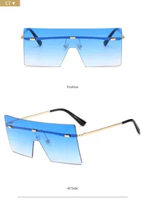 Occhiali da sole oversize con lenti piatte blu sfumate e montatura elegante in metallo oro.