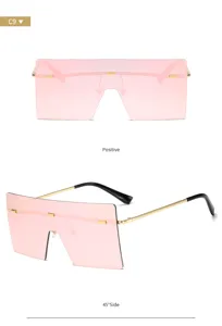 Occhiali da sole oversize con lenti rosa e stanghette dorate, dettaglio di moda urbana.