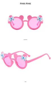 Detail view of cute pink children sunglasses featuring playful bear ears and pretty bow decor.