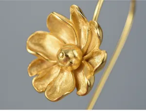 Close-up detail shot of exquisite jasmine flower earrings featuring textured gold-plated petals.