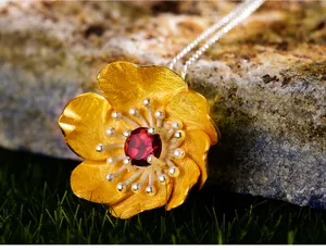 Dettaglio pendente fiore in argento S925 granato rosso naturale artigianato squisito.