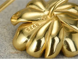 Close-up detail of the gold-plated sterling silver flower earring, showing S925 stamp clearly.