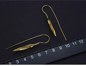 Close-up of golden leaf tassel earrings, delicate metal texture and exquisite craftsmanship.
