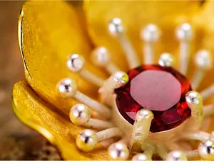 Dettaglio del ciondolo fiore in argento S925 granato naturale, raffinato gioiello artigianale.