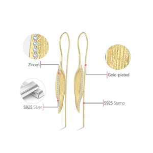 Close-up view of gold-plated sterling silver leaf earrings with shimmering zircon details.