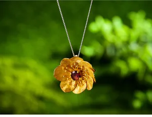 Vista di dettaglio del ciondolo a fiore in argento sterling granato rosso placcato oro.