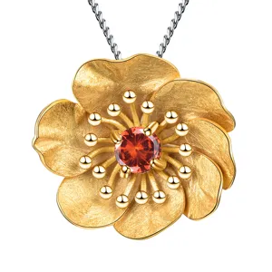 Splendida collana con ciondolo a fiore in argento dorato e granato rosso brillante al centro.