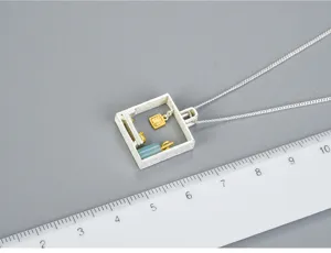 Primo piano della collana con ciondolo quadrato in argento con gatto e pietra naturale.