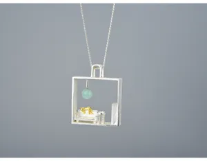 Dettaglio del ciondolo in argento con gatto pigro e pietra verde in una cornice per stanza.
